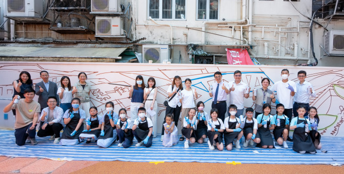 壁畫創作開始前,市建局團隊、學生、區議員及藝術家團隊在牆壁前合影,準備一同完成「城與海」主題壁畫。